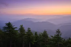 Reve v1.0 — A misty mountain range at sunrise, layers of purpl