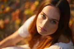 Reve v1.0 — A young woman with freckles and green eyes, golden