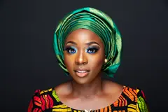 Reve v1.0 — A woman with elaborate gele headwrap and bold eye 