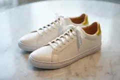 Reve v1.0 — A pair of white leather sneakers on a marble count
