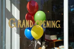 Reve v1.0 — A storefront window with GRAND OPENING painted in 