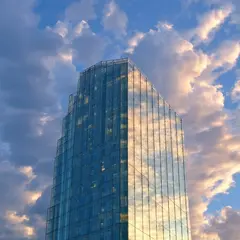 SD 3.5 Large — A modern glass skyscraper reflecting clouds at sun