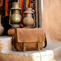 SD 3.5 Large — A leather messenger bag on a sun-dappled step in a