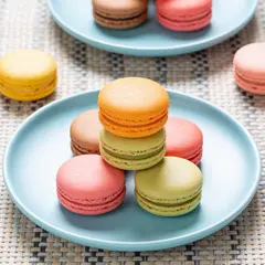 Seedream v4.5 — A stack of colorful macarons on a pastel blue plat