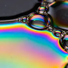 Seedream v4 — A macro photograph of oil droplets on water, iride