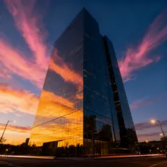 Seedream v4 — A modern glass skyscraper reflecting clouds at sun