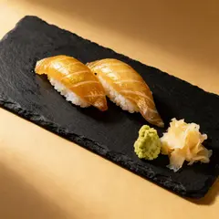 Seedream v4 — A perfectly plated sushi omakase on a black slate 