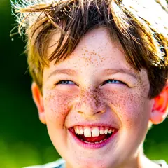 Wan 2.6 T2I — A freckled boy with bright blue eyes and messy hai