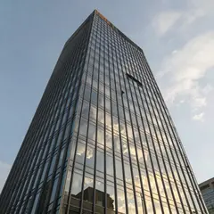 Z-Image Turbo — A modern glass skyscraper reflecting clouds at sun