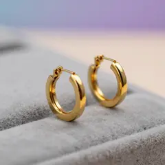 Z-Image Turbo — A pair of gold hoop earrings on a velvet jewelry d